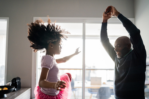 Father and daughter dancing ballet at home