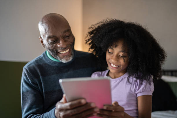 istock Father and daughter using digital tablet at home 1329183293