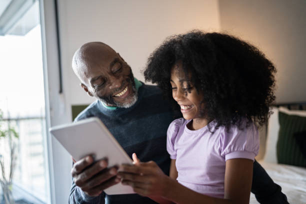 istock Father and daughter using digital tablet at home 1329183310