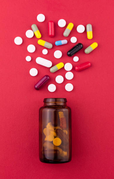 istock Bottle with assorted pills on a red background. Top view. 1329188462