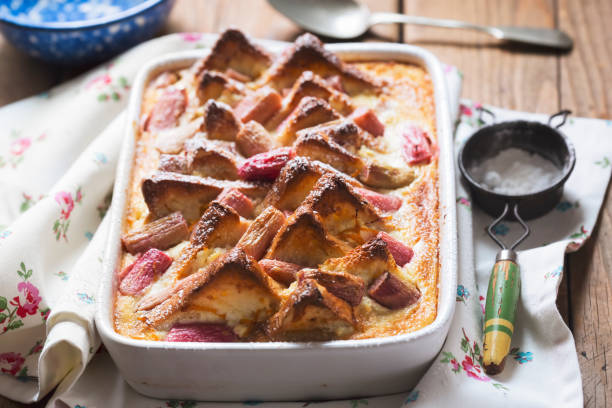 Rhubarb ricotta bread and butter pudding with icing sugar stock photo
