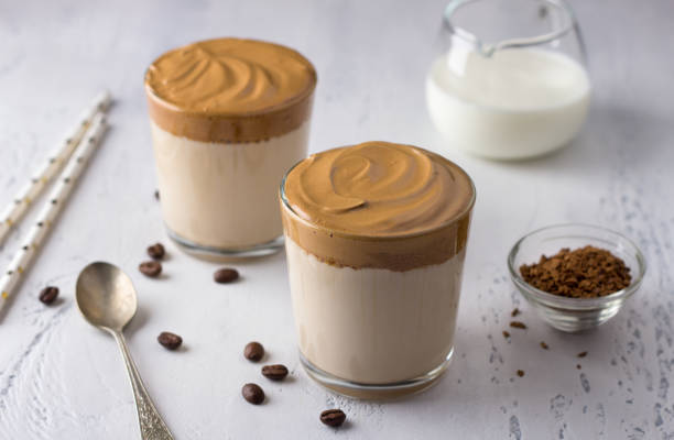 istock Two glasses with Dalgona coffee, cold cocktail with whipped coffee foam, popular trending drink on a light textured background 1329189424