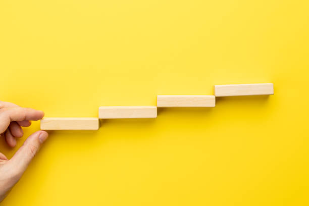 istock stairs made by wooden bricks over yellow background. above view. abstract creative staircase. business strategy concept. achievement conceptual 1329190605