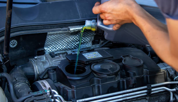 istock An auto mechanic changing oil pours oil into a car engine. 1329191079