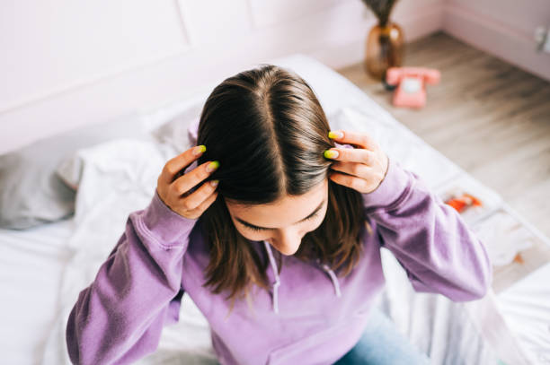 young brunette woman showing her scalp, hair roots, color, grey hair, hair loss or dry scalp problem. - full hair imagens e fotografias de stock