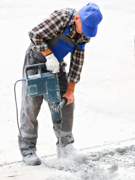 istock A worker repairs the road surface with a jackhammer on a summer day. Construction works on the road 1329193546