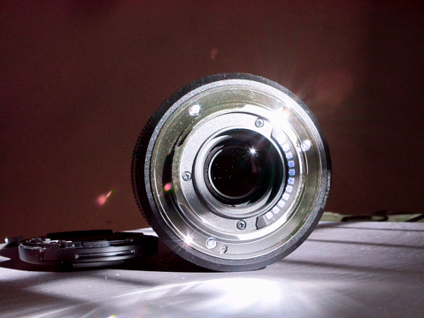 Zoom wide angle focus lens for Digital camera presented on center with sunlight reflection.