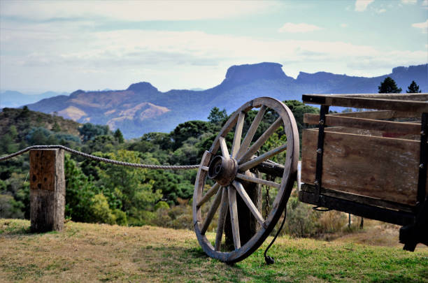 A wooden wagon wheel and the landscape of Pedra do Baú seen from Campos de Jordão