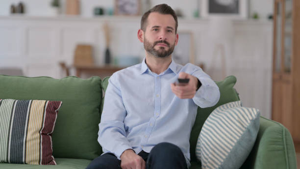 istock Young Man Watching Television in Bed 1329204676