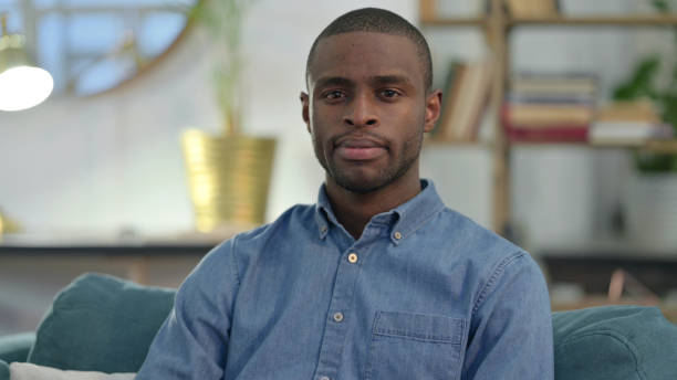 istock Young African Man Looking at Camera at Home 1329204678