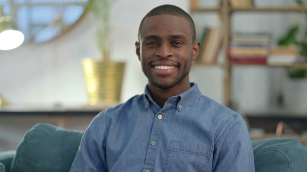 istock Young African Man Smiling at Camera at Home 1329204699