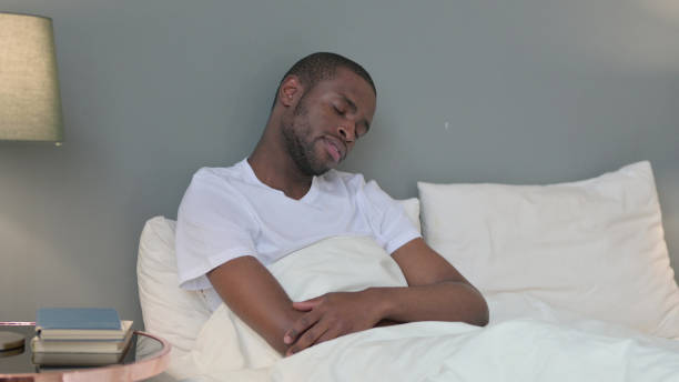 istock Sleepy Young African Man Taking Nap in Bed 1329204772