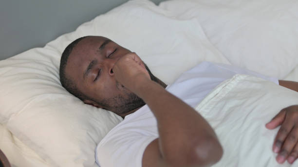 istock Young African Man with Cough Laying in Bed 1329204858