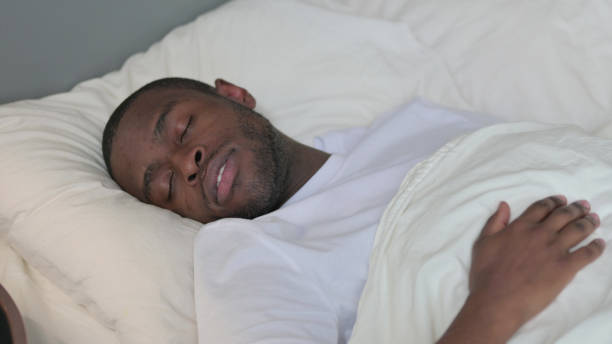 istock Young African Man Going to Bed and Sleeping 1329204888