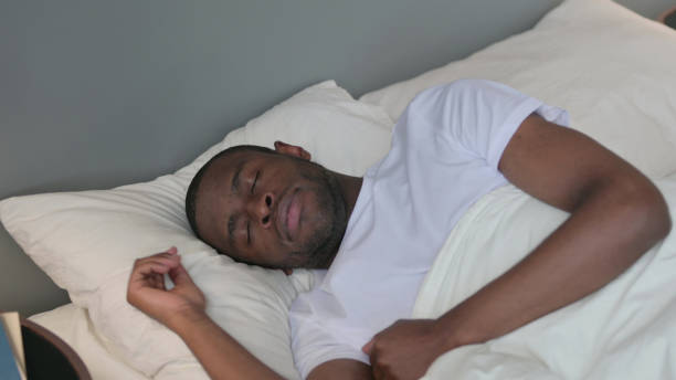 istock Young African Man Sleeping in Bed 1329204908