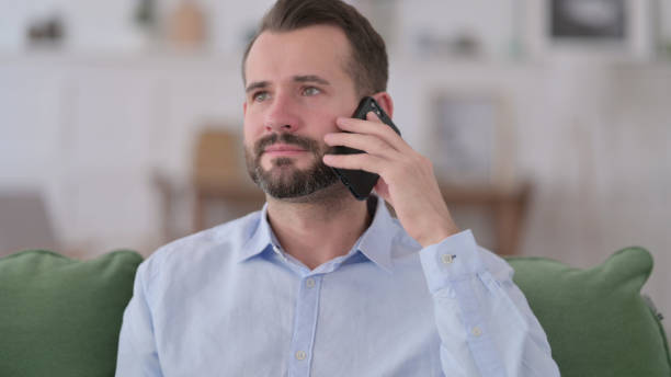 istock Busy Young Man Talking on Phone 1329204920