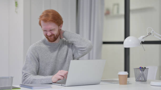istock Beard Redhead Man having Neck Pain while Typing on Laptop 1329205809