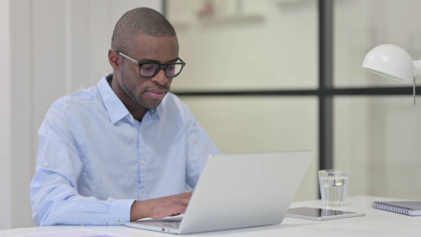 istock African Man Working on Laptop in Office 1329206077