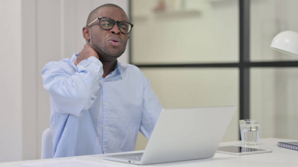 istock African Man having Neck Pain while Typing on Laptop 1329206108