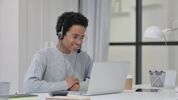 istock African Woman using Headset for Video Chat on Laptop 1329206166
