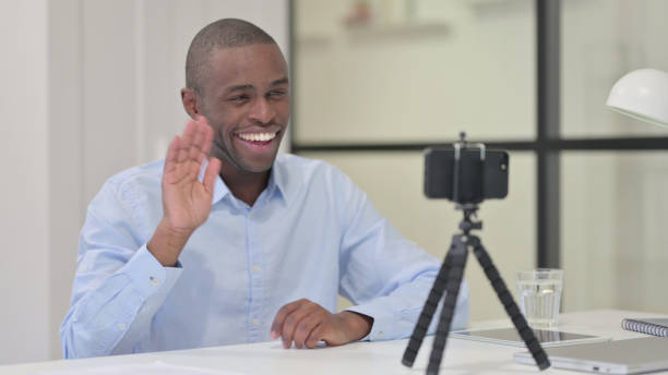 istock Talking African Man Blogging with Smartphone at Work 1329206824