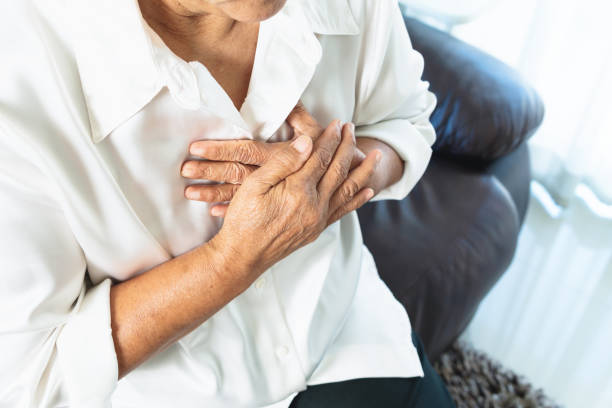 old woman having heart attack and grabbing her chest - kalp krizi stok fotoğraflar ve resimler