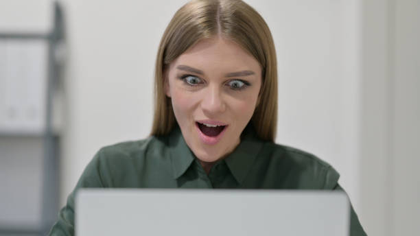 istock Close Up of Woman Celebrating while using Laptop 1329207233