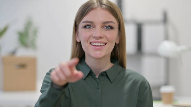istock Young Woman Pointing and Inviting 1329207501