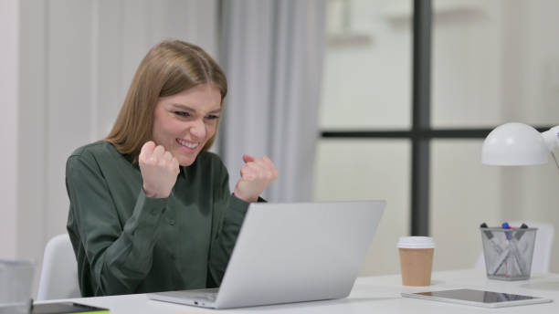 istock Successful Young Woman Celebrating on Laptop 1329207527