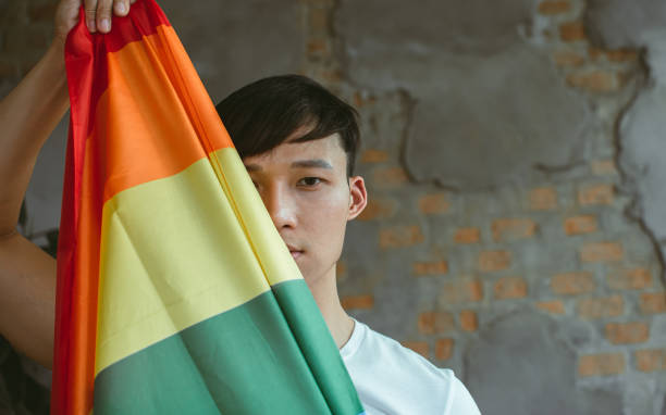 istock Asian man holding rainbow flag 1329207581