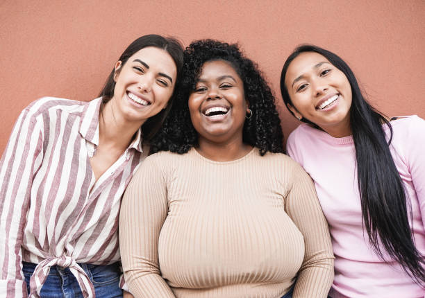 mulheres latinas felizes com diferentes cores de pele olhando na câmera - conceito de pessoas multirraciais, amizade e felicidade - young women friendship smiling individuality - fotografias e filmes do acervo