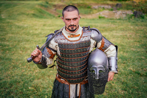 Medieval knight in armor with sword outdoor
