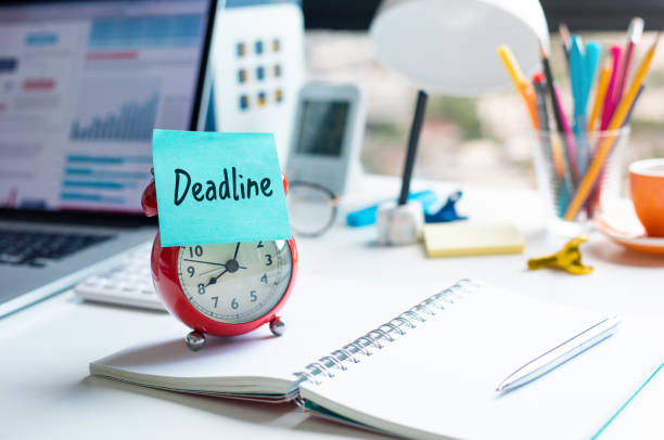 istock Deadline and work concepts with text on alarm clock on desk. 1329211284