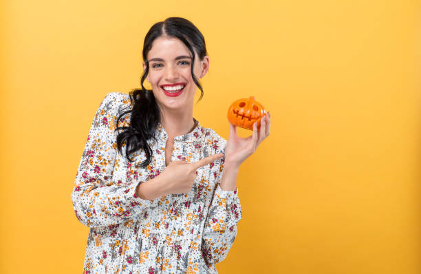istock Young woman holding a pumpkin 1329214006