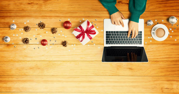 istock Christmas ornaments with person using a laptop computer 1329214045