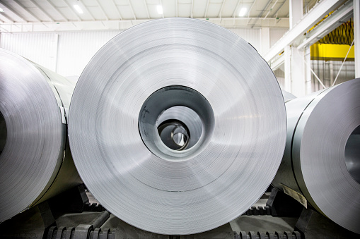 A close up photograph of rolled aluminum metal sheets.