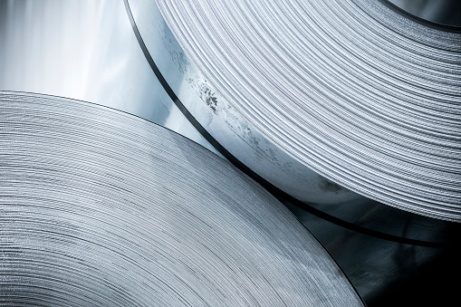 A macro photograph of thin rolled aluminum metal sheets.
