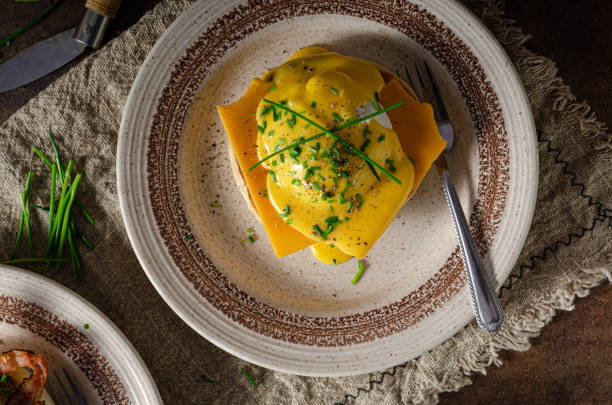 Delicious eggs benedict Organcic eggs benedict with bacon, cheddar cheese and herbs and hollandaise sauce hollandaise sauce stock pictures, royalty-free photos & images