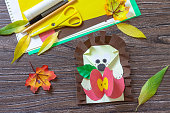 Autumn Greeting postcard hedgehog with an apple on a wooden table. Handmade. Project of children's creativity, handicrafts, crafts for kids.