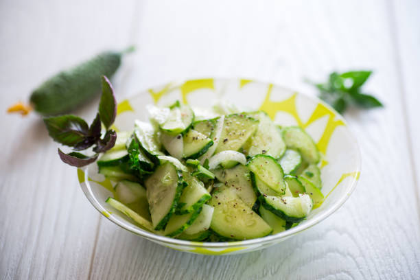 fresh organic cucumber salad with herbs and basil in a plate on the table