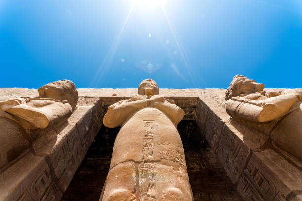 Pyramids of Giza, Giza Necropolis, Egypt - July 14, 2023: Man walking with camels at Great Sphinx of Giza. The Great Sphinx of Giza is a limestone statue of a reclining sphinx, a mythical creature with the head of a human and the body of a lion.