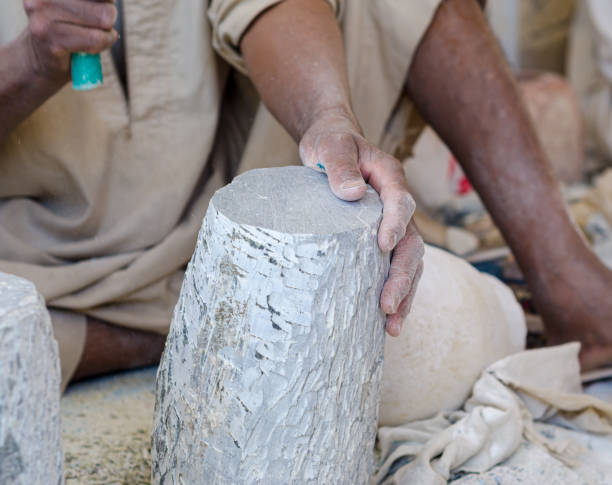 istock hands of a male Egyptian sculptor while working with a stone alabaster 1329234220