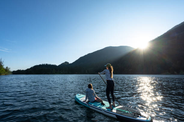 istock Mother and daughter on a paddle board adventure 1329239116