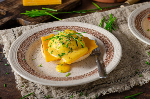 Delicious eggs benedict Organcic eggs benedict with bacon, cheddar cheese and herbs and hollandaise sauce hollandaise sauce stock pictures, royalty-free photos & images