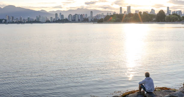 He looks off across the water, towards downtown Vancouver