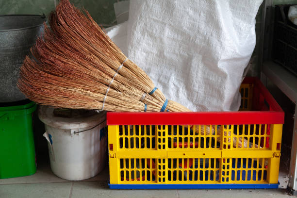 A new broom and a white plastic bag lie in a yellow plastic box close-up