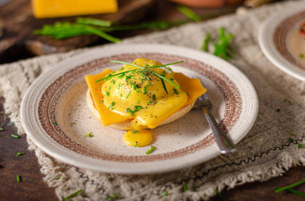 Delicious eggs benedict Organcic eggs benedict with bacon, cheddar cheese and herbs and hollandaise sauce hollandaise sauce stock pictures, royalty-free photos & images