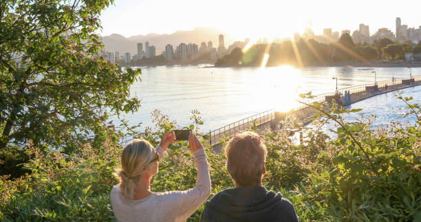 They take photos as the sun rises over downtown Vancouver in the distance