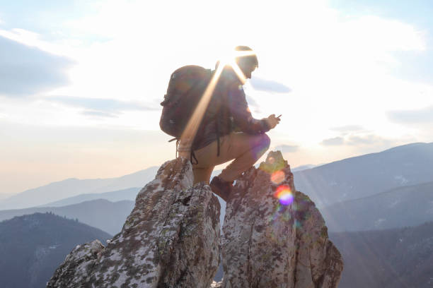 istock Young man climbs up sunny mountain ridge, to summit 1329246388