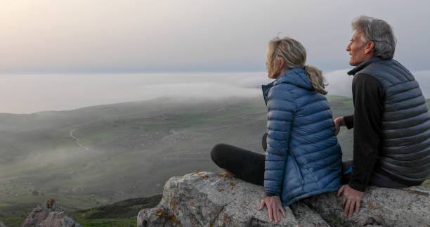 istock Mature couple relax on mountain ridge at sunrise 1329246546